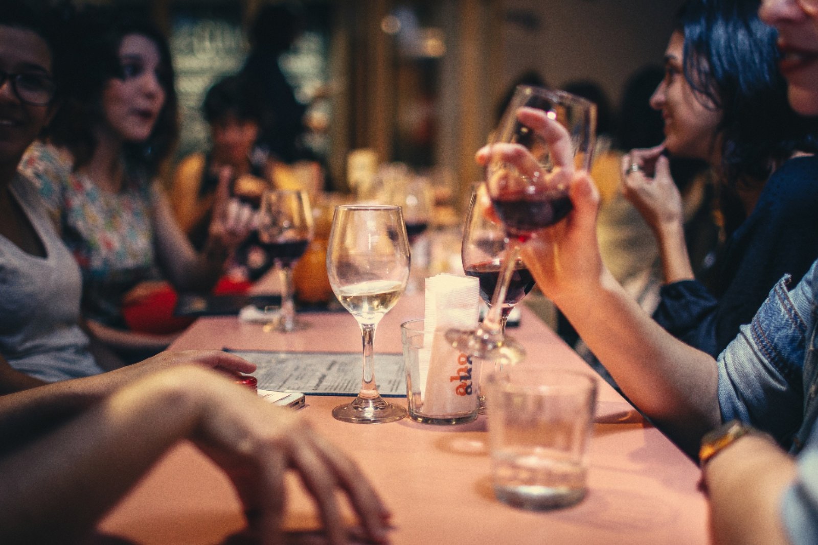 Grupo de amigos brindando en una mesa larga