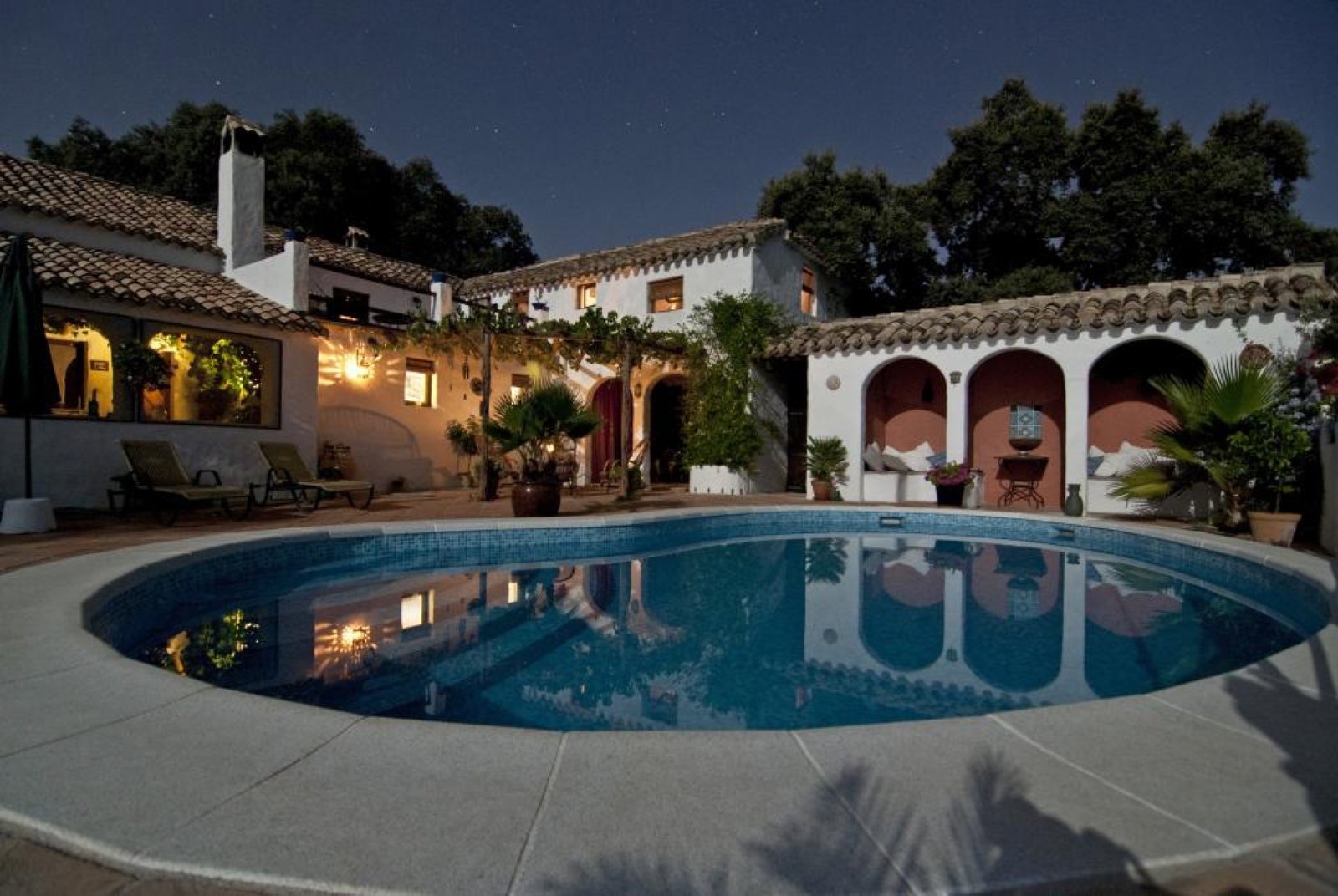 Casa con piscina iluminada de noche